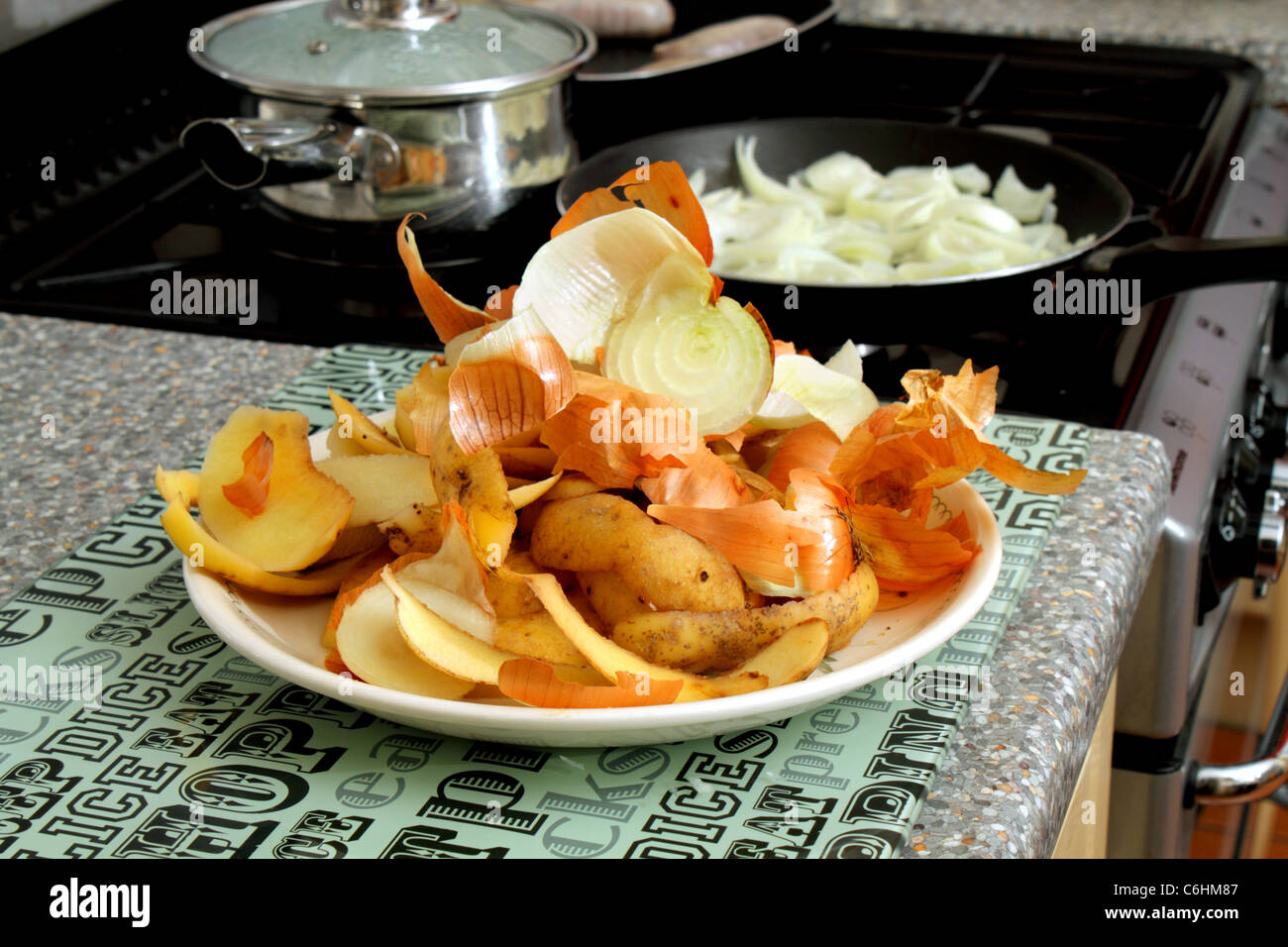 Vegetable peelings ready for the compost heap, with sausages and onions in background Stock Photo