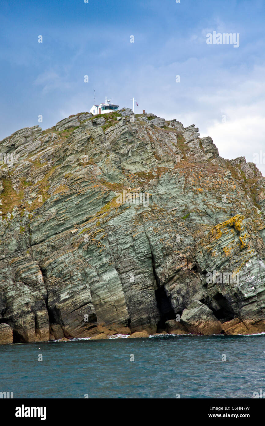 The lookout coastguard station at Prawle Point, Devon, England, UK with a couple of sheep caught on a ledge below Stock Photo