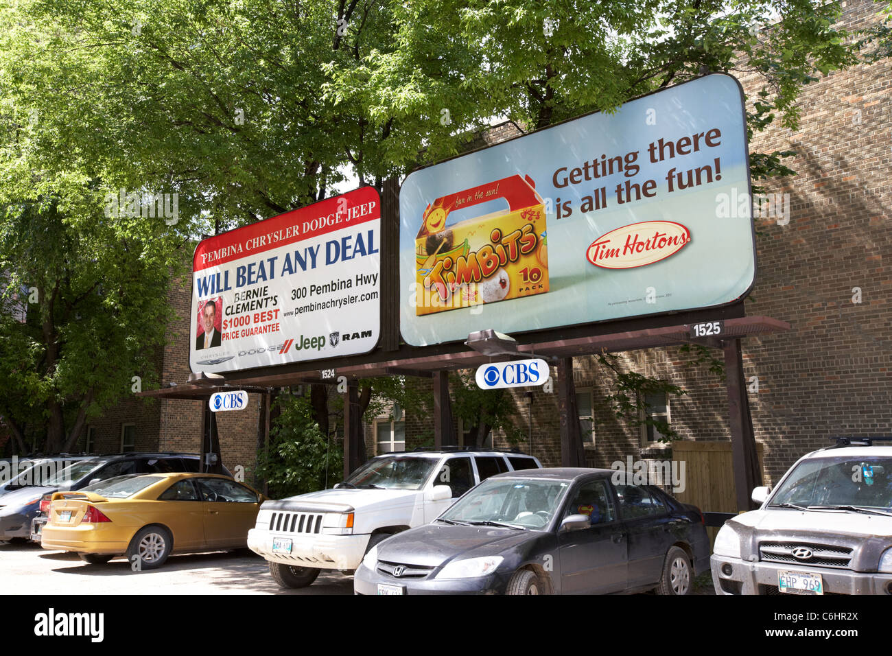 advertising boards for tim hortons and a local car dealer in a car park in winnipeg manitoba canada Stock Photo