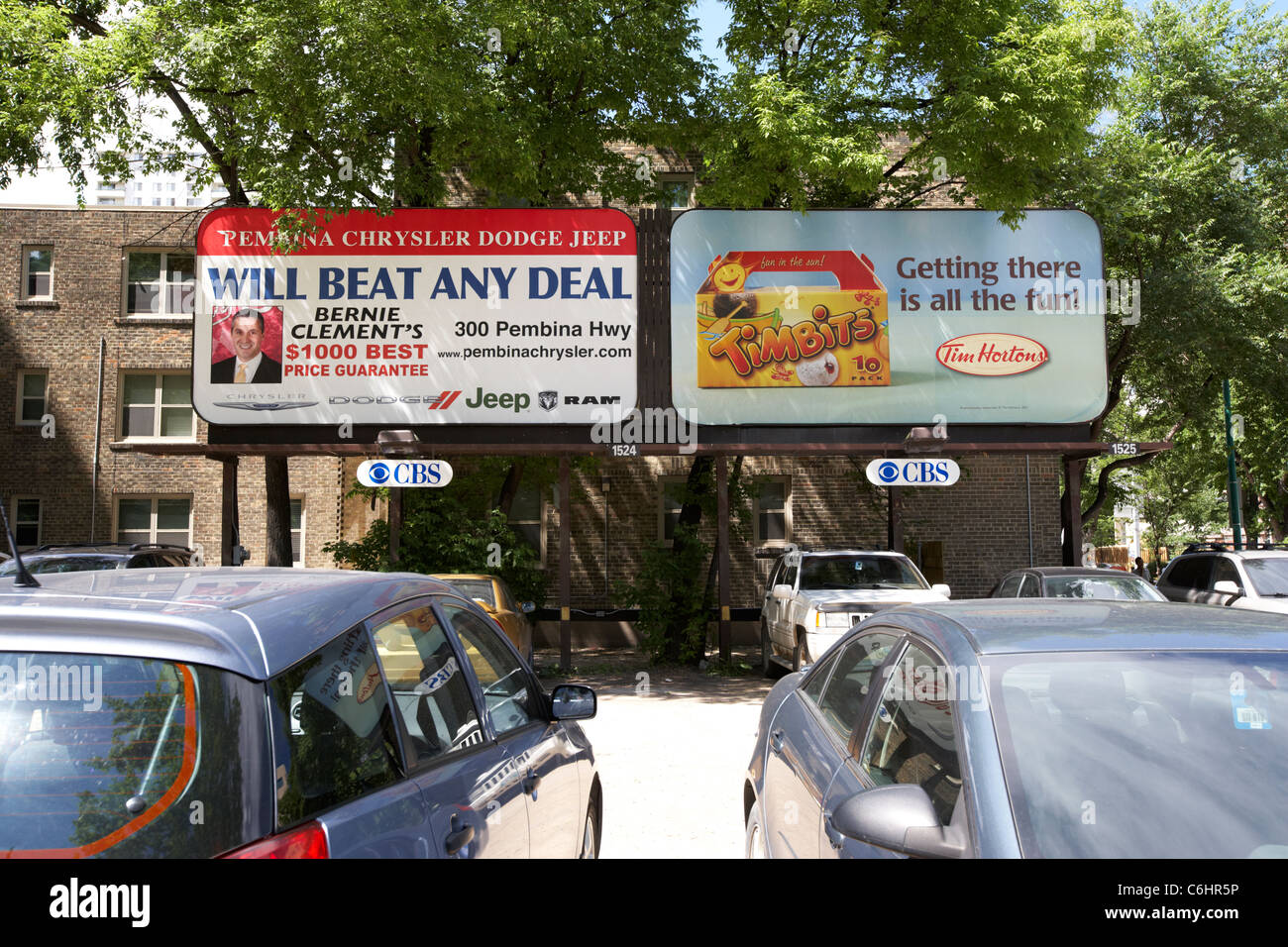 advertising boards for tim hortons and a local car dealer in a car park in winnipeg manitoba canada Stock Photo