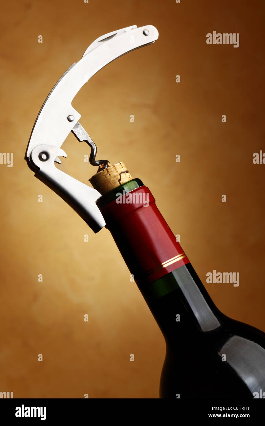 Corkscrew opening wine bottle over dark background Stock Photo Alamy