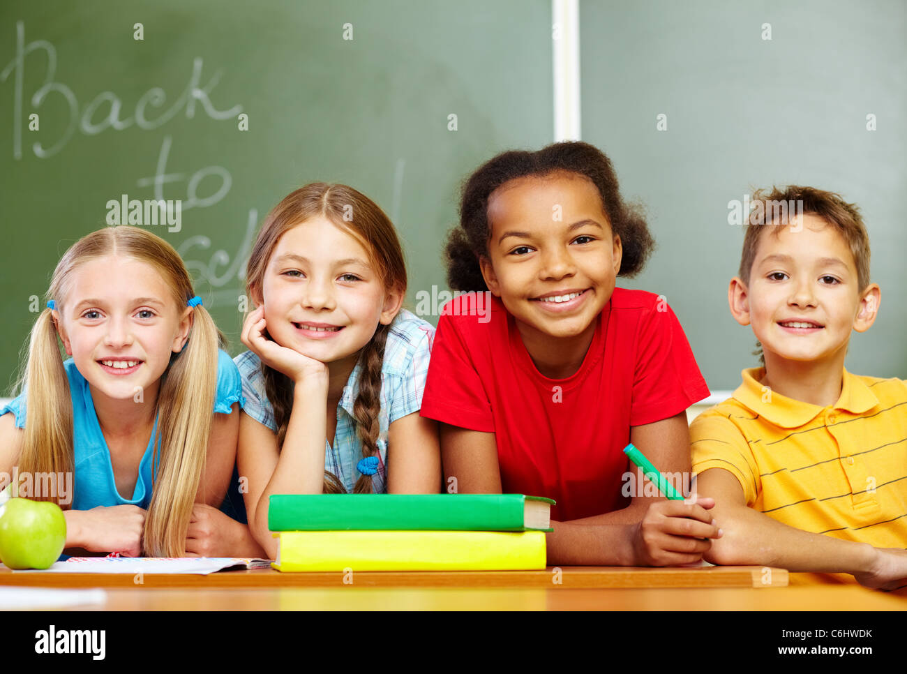 Portrait of smart schoolchildren looking at camera in classroom Stock