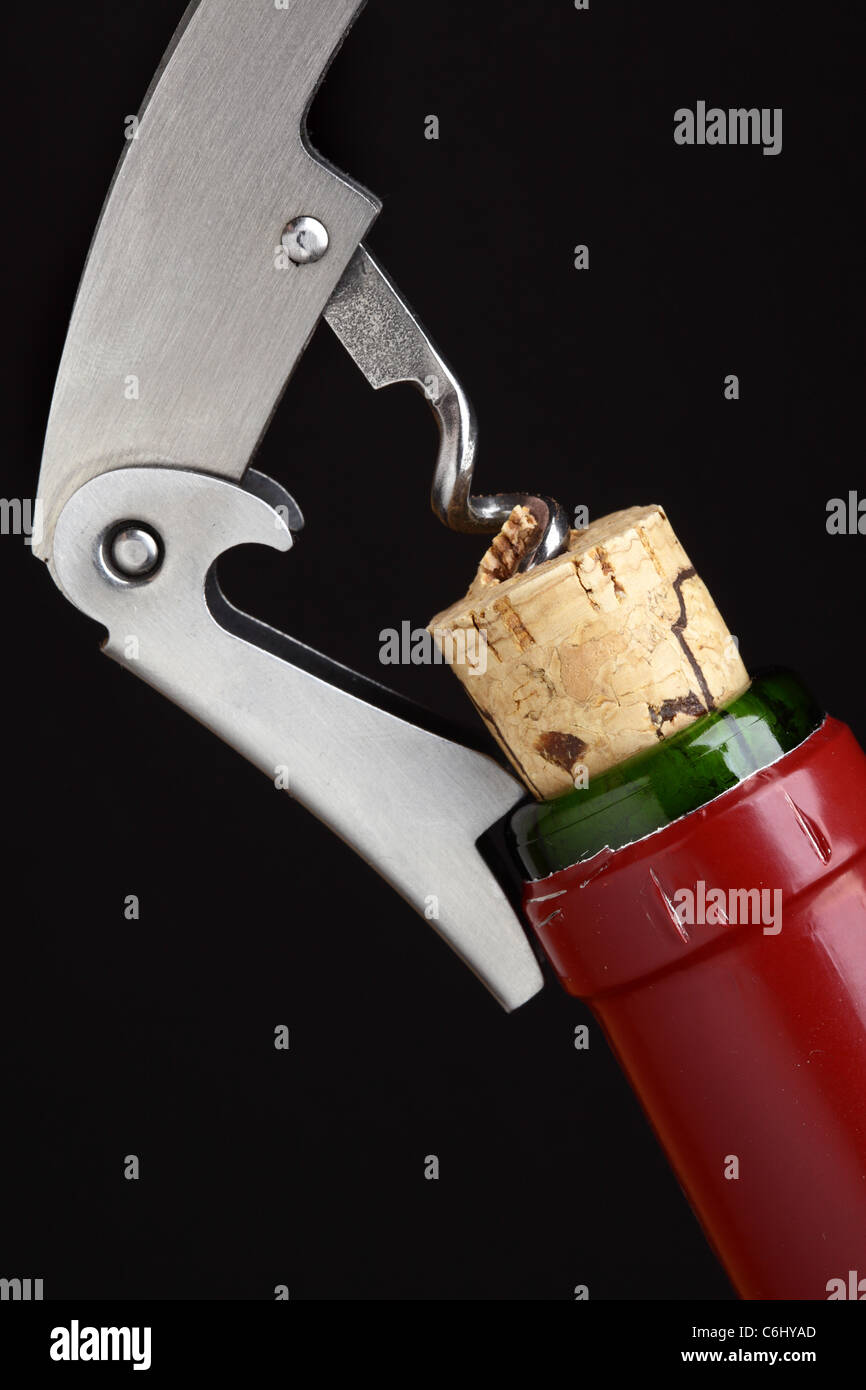 Corkscrew opening wine bottle over black background Stock Photo Alamy