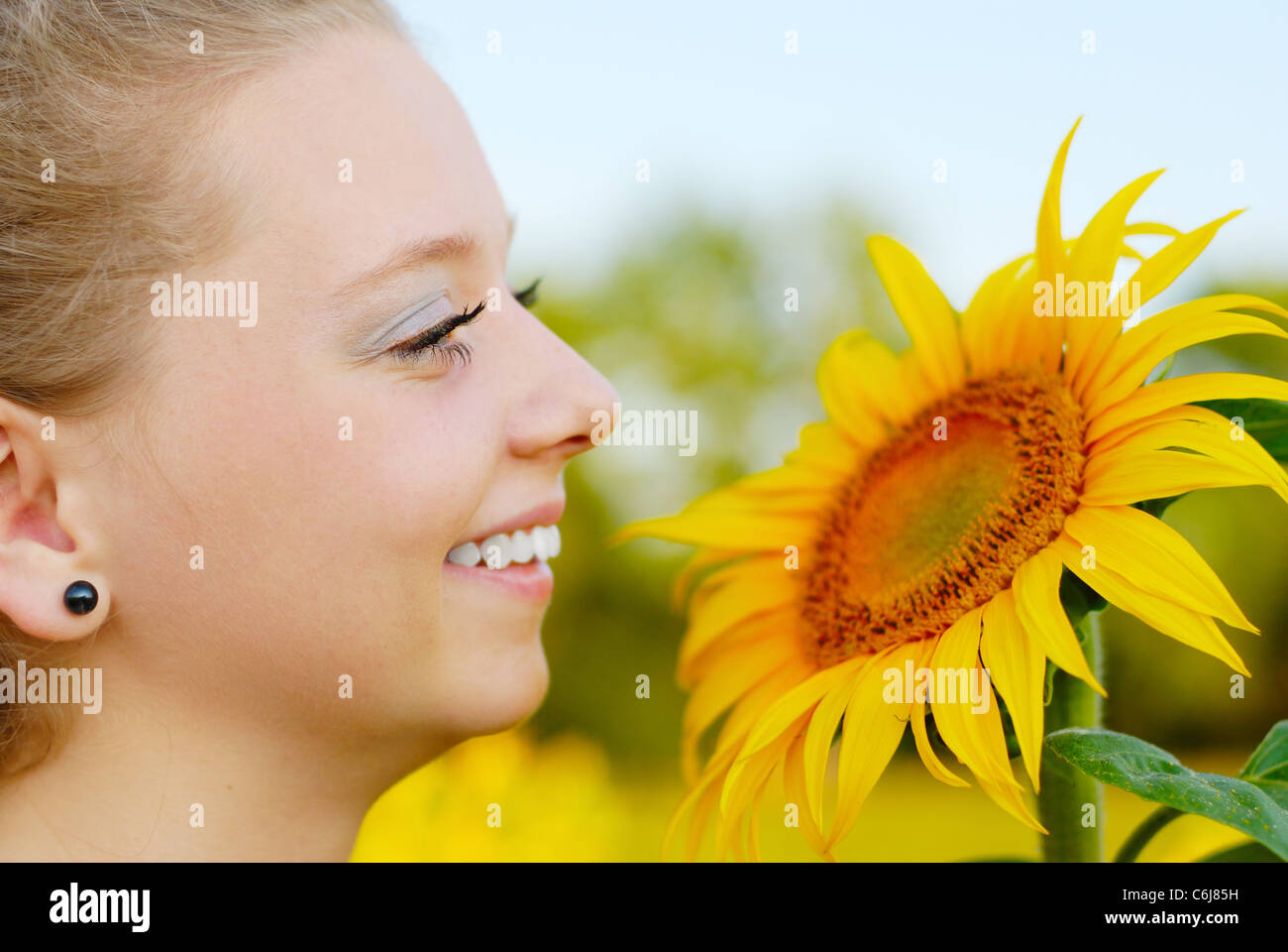 Beautiful smiling young woman with sunflower Stock Photo - Alamy