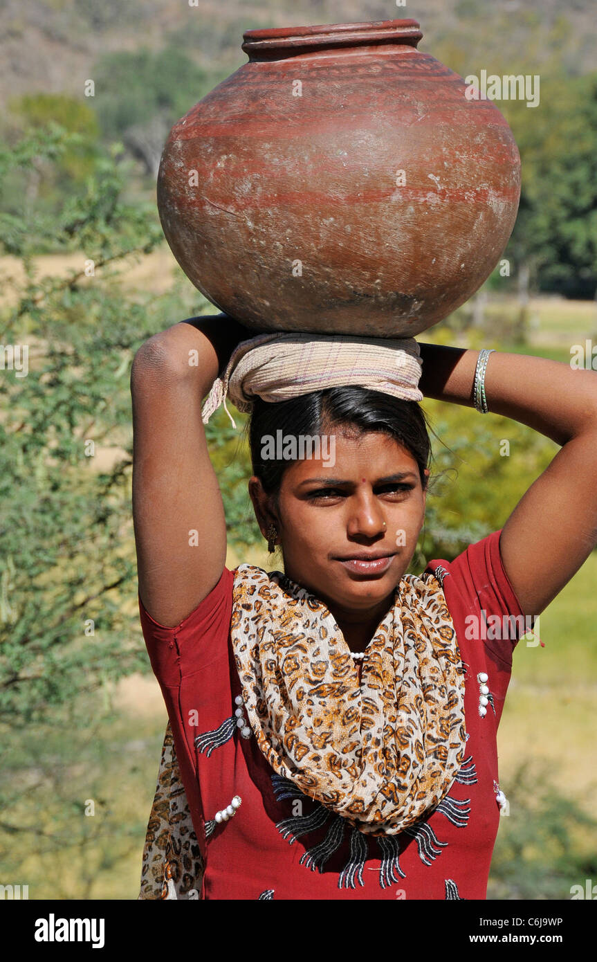 Portrait village girl with water jar on head Aravalli Hills Rajasthan India Stock Photo