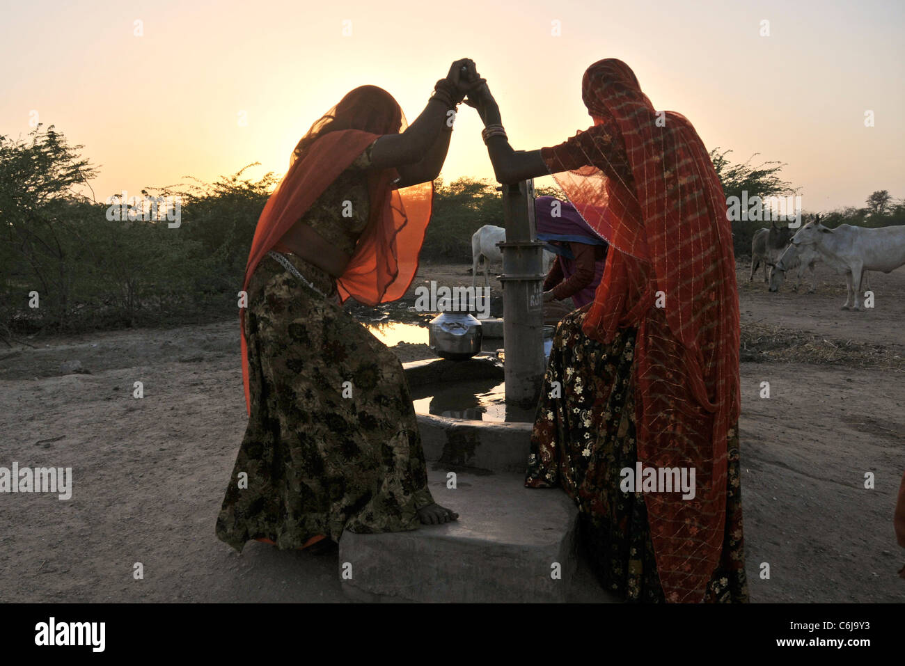 Silhouette women drawing water from well Aravalli Hills Rajasthan India Stock Photo