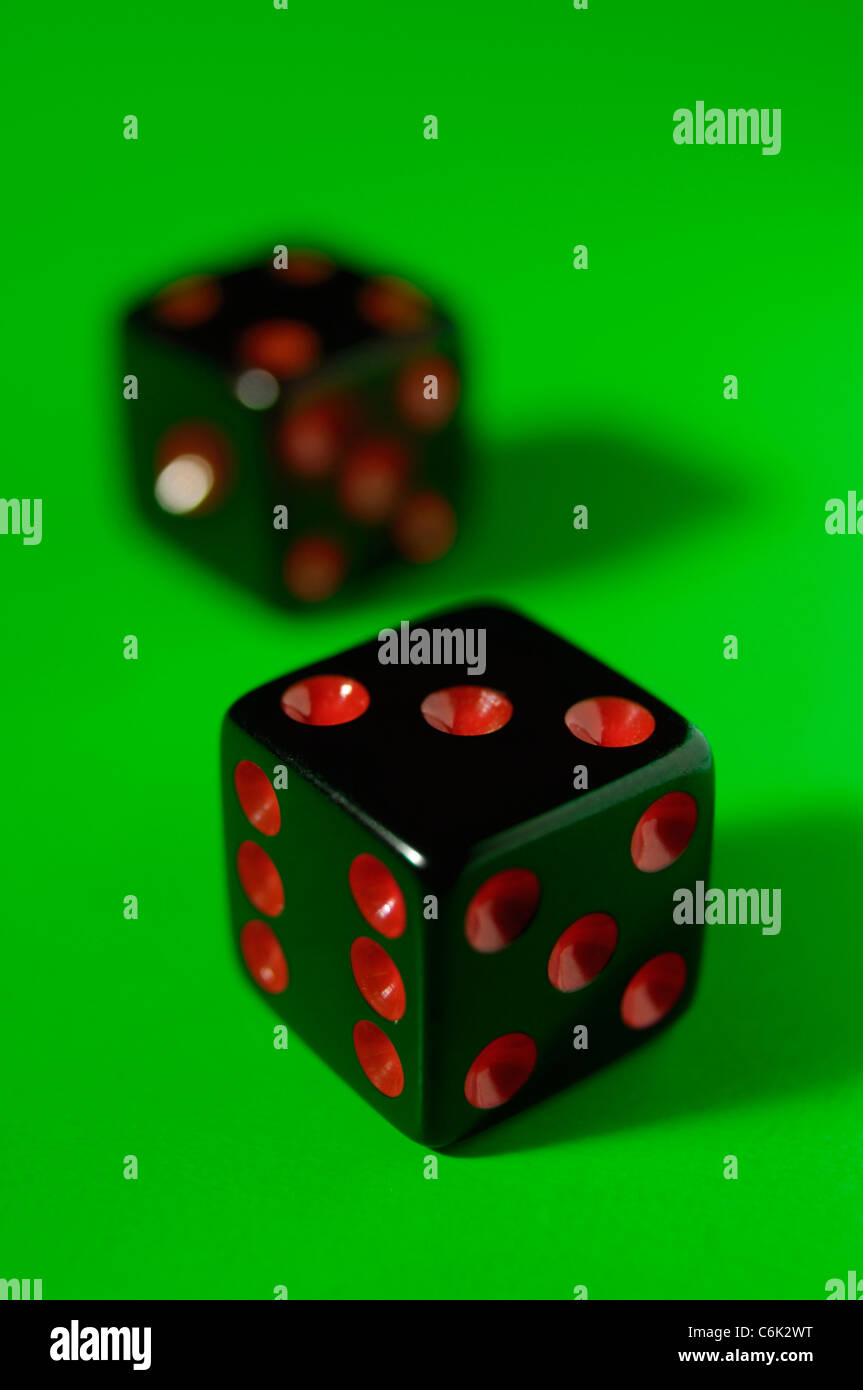 Pair of black dice isolated on green background Stock Photo Alamy
