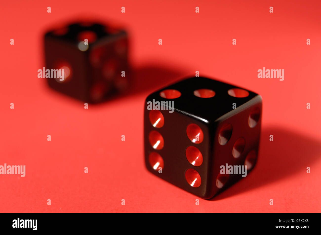 Pair of black dice isolated on red background Stock Photo