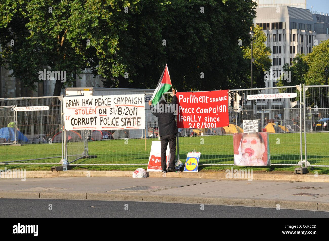 Palestinian man putting up flag Brian Haw Peace Camp outside Parliament 1st September 2011 day tents removed Westminster Council Stock Photo