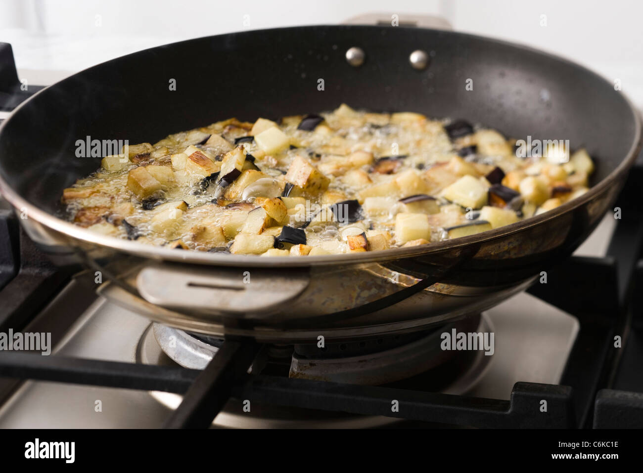 Sauteing eggplant in frying pan Stock Photo Alamy
