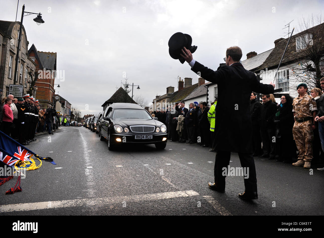 Military personnel and public mourners line the high street as four coffins of Marines killed in Afganistan pass through the tow Stock Photo