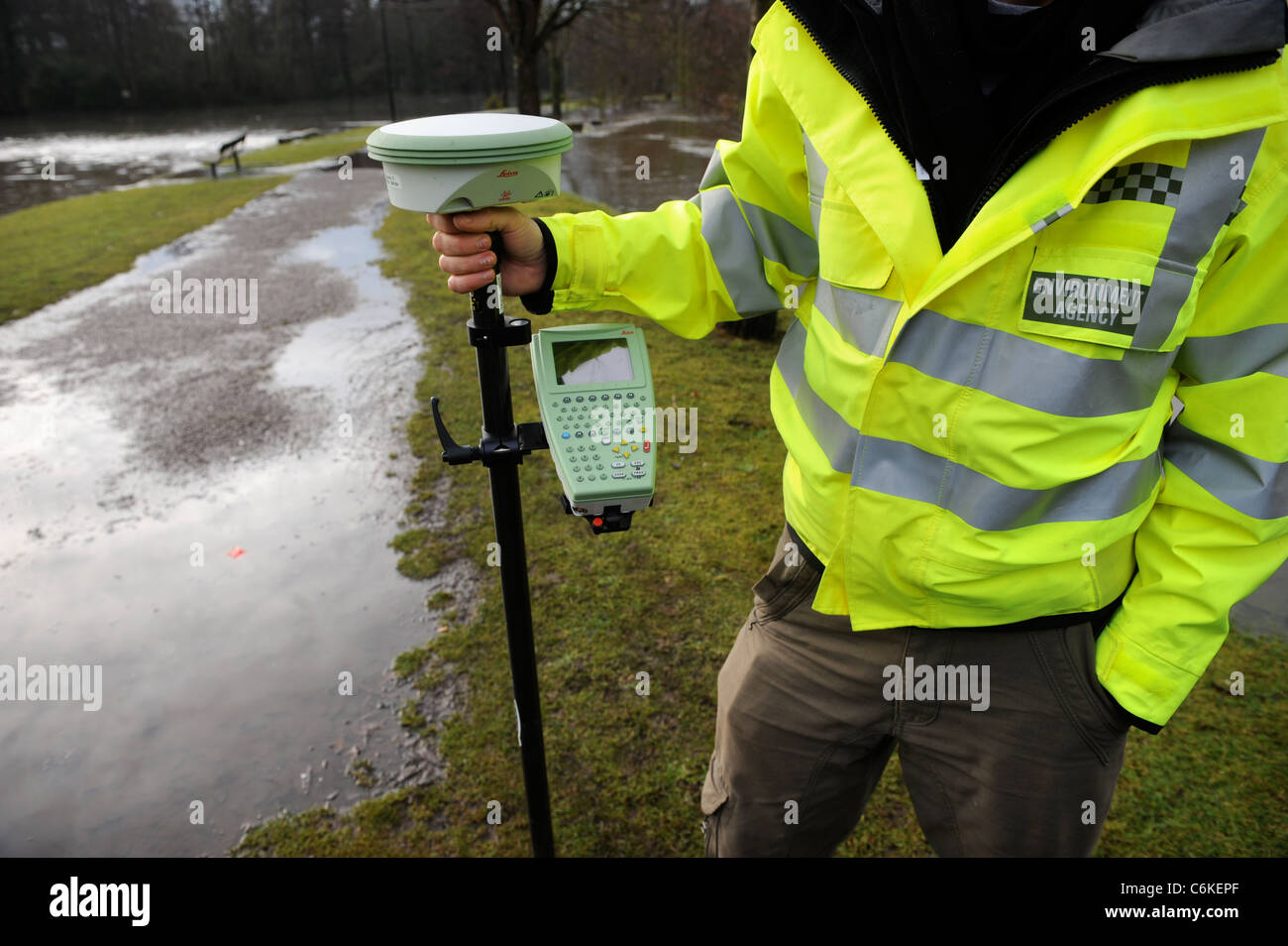 An officer from the Environment Agency monitoring flood levels using a GPS or GNSS device near the River Lyd in Lydney, Gloucest Stock Photo