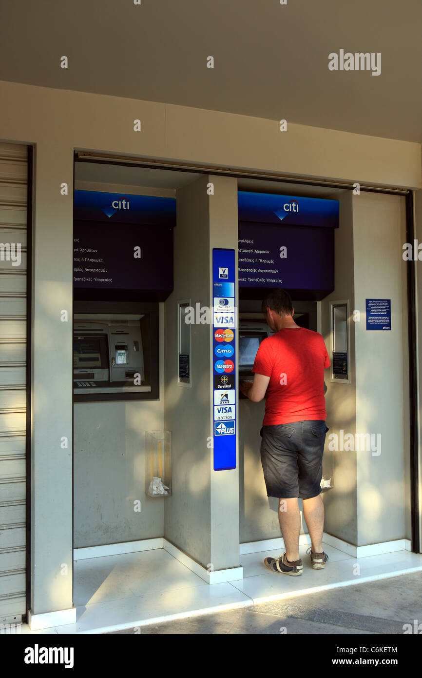 Man at Citi bank ATM machine in Athens Greece Stock Photo