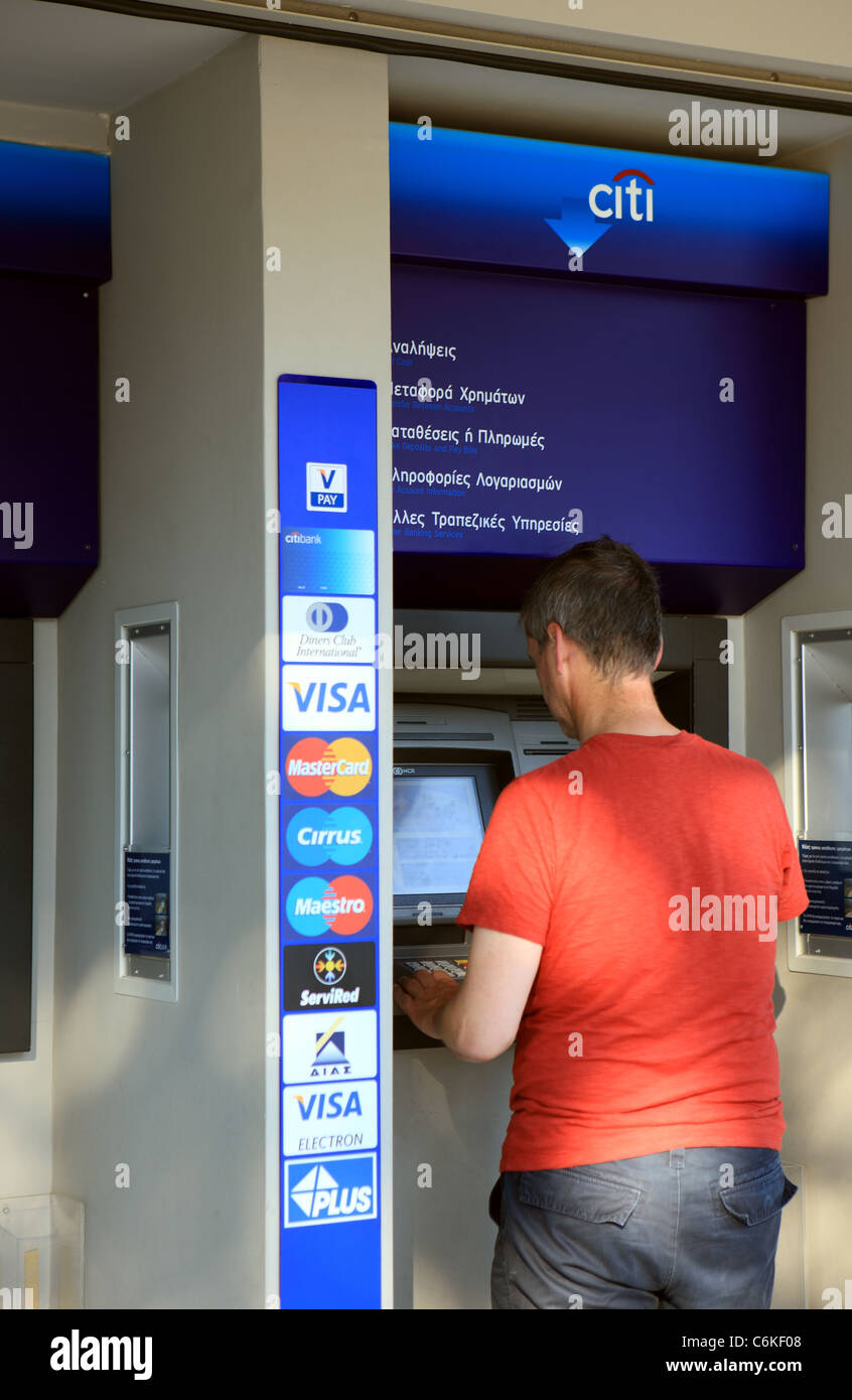 Man at Citi bank ATM machine in Athens Greece Stock Photo