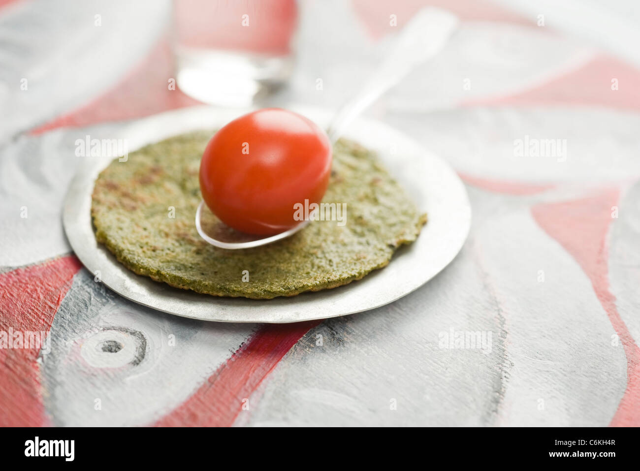 Savory spiced crepes topped with cherry tomato Stock Photo