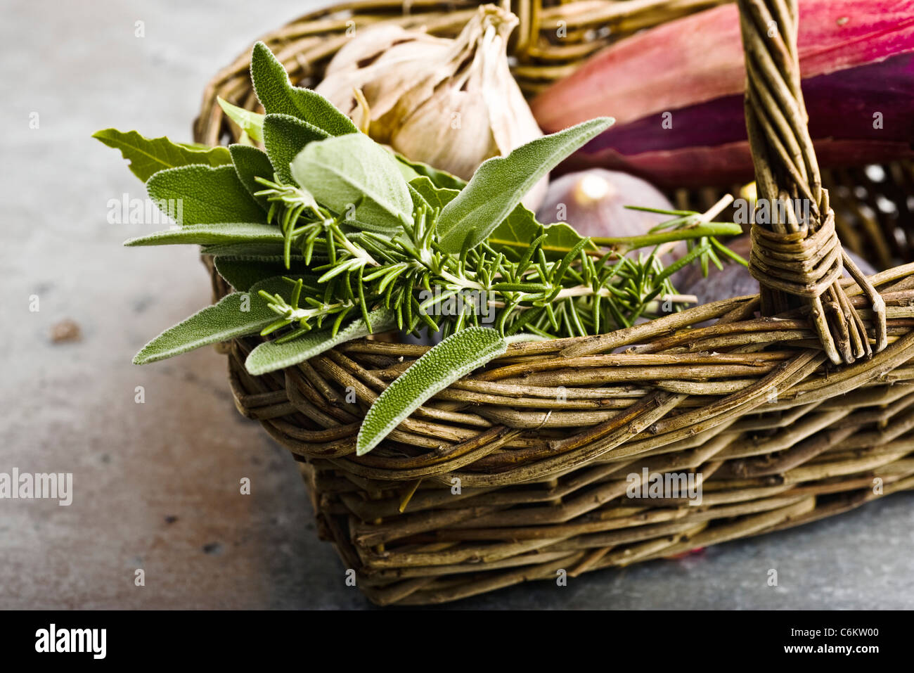 Fresh rosemary, sage, and other ingredients in basket Stock Photo