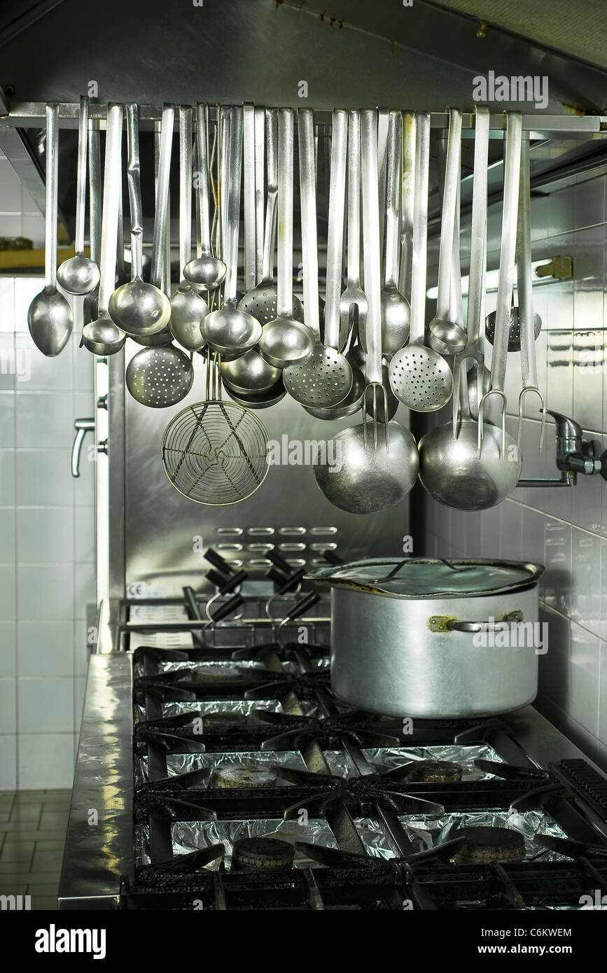 https://c8.alamy.com/comp/C6KWEM/cooking-utensils-hanging-in-kitchen-C6KWEM.jpg