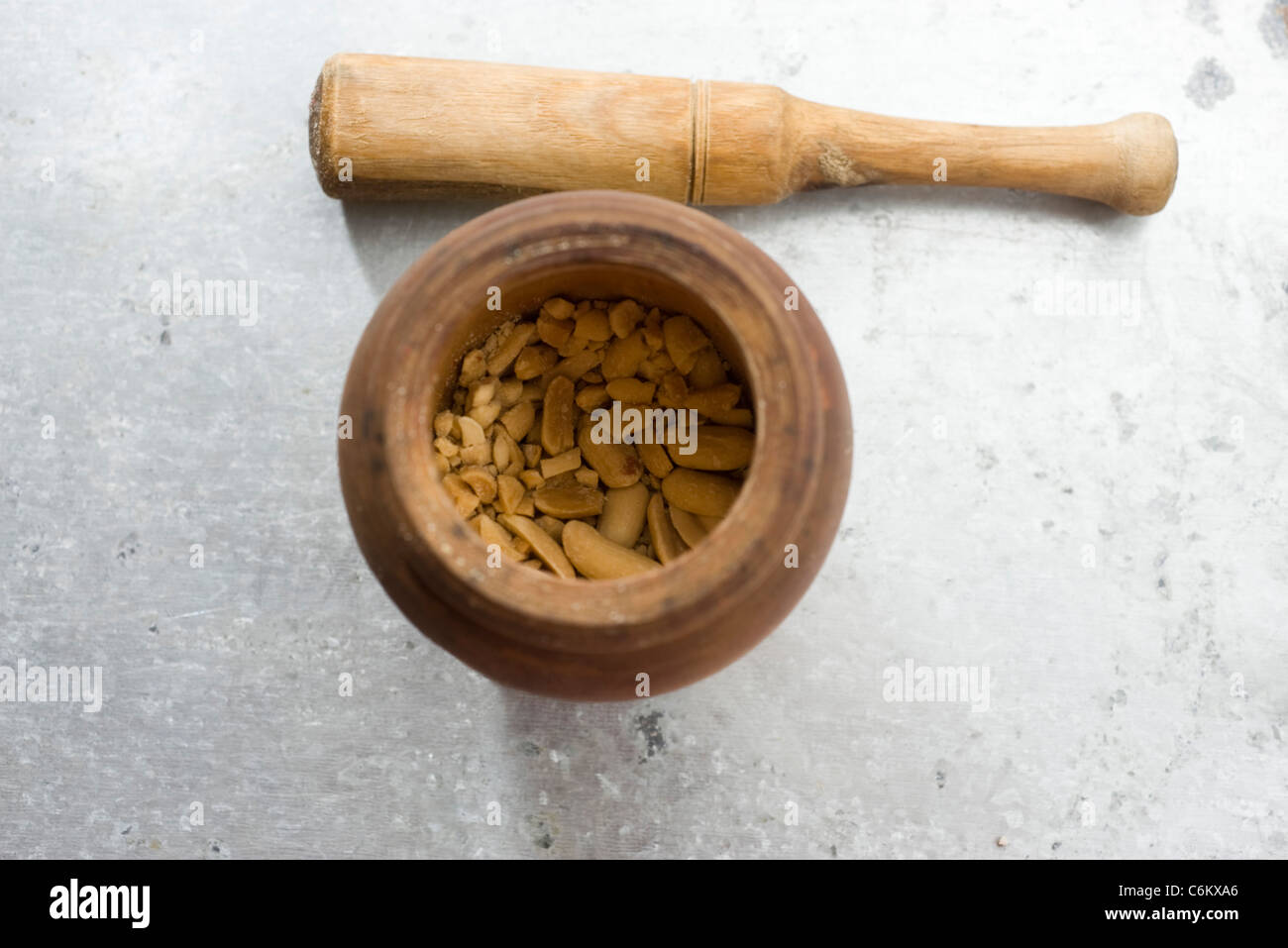 Crushing peanuts with mortar and pestle Stock Photo