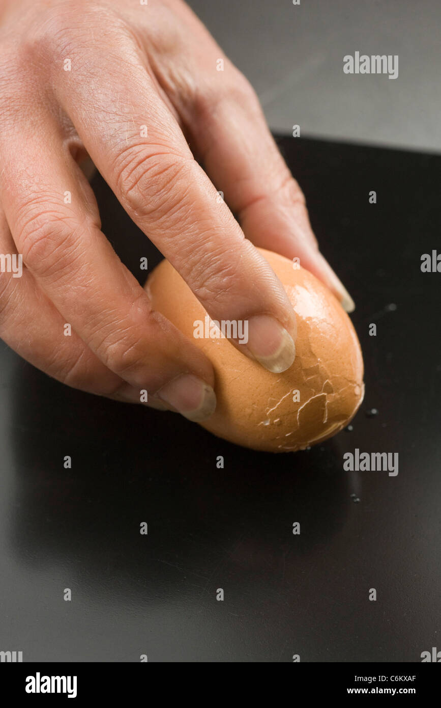 Cracking hardboiled egg Stock Photo Alamy