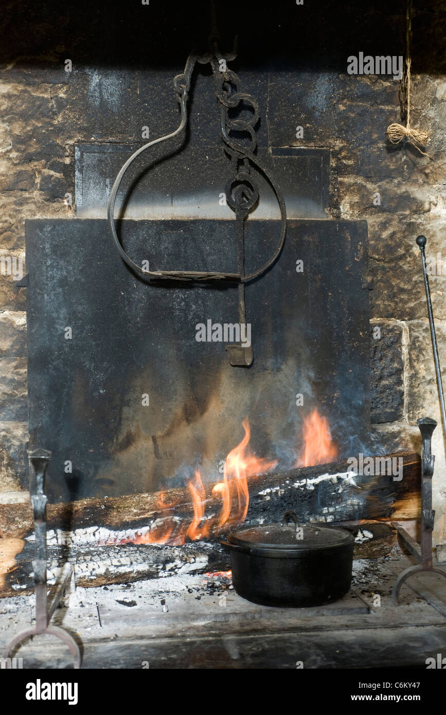Pot of food next to wood fire Stock Photo