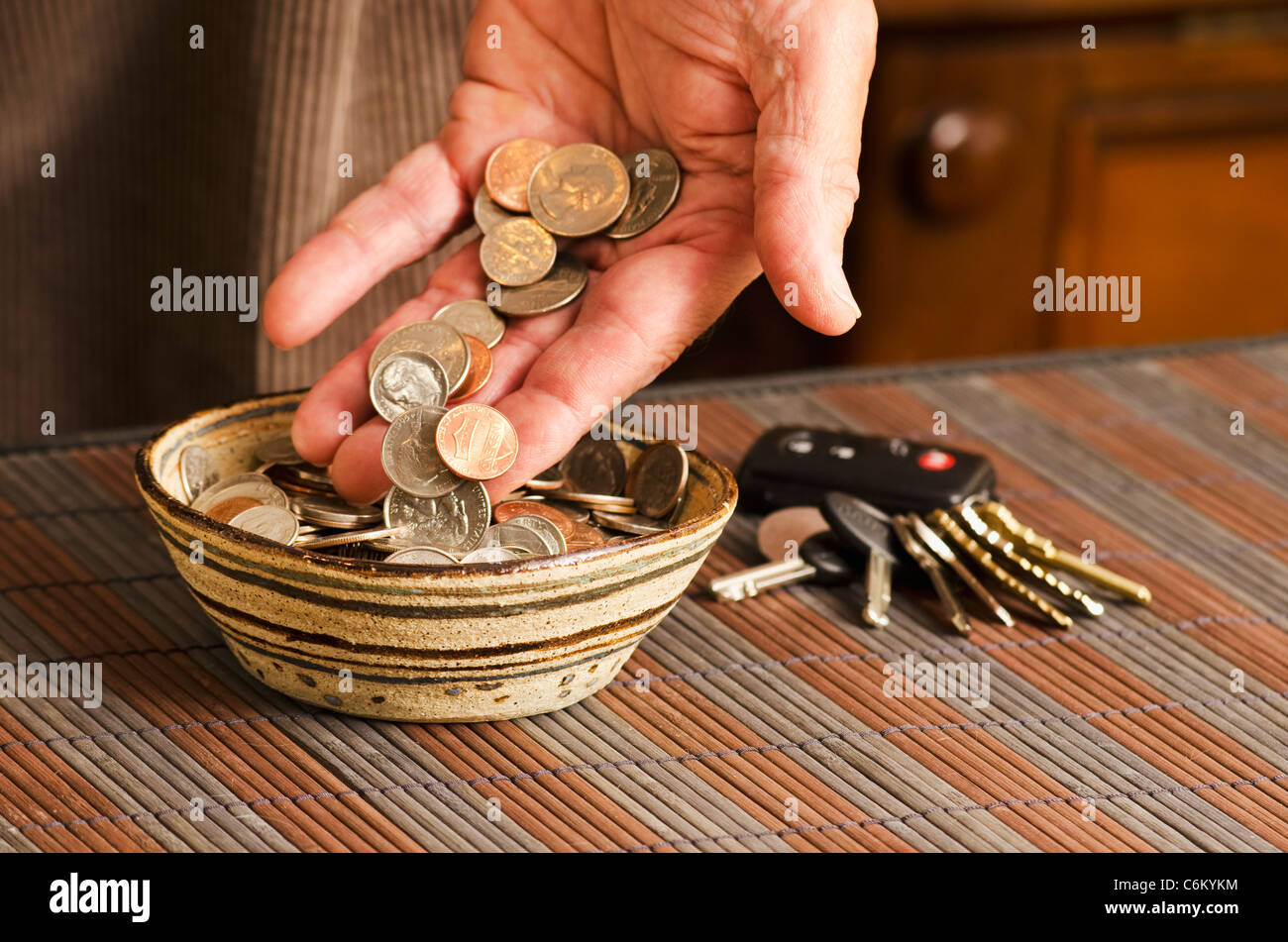 man placing daily pocket change in bowl Stock Photo Alamy