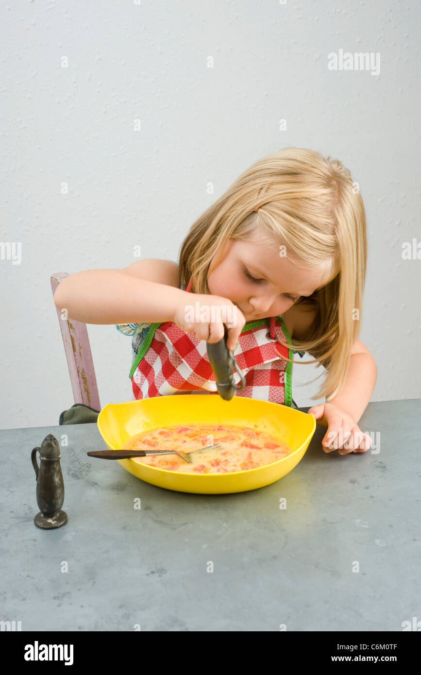 Little girl seasoning food Stock Photo