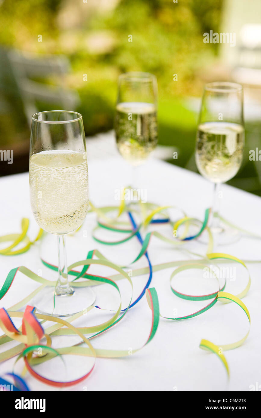 Champagne flutes on table decorated with party streamers Stock Photo