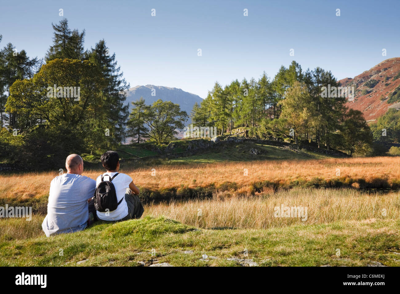 A mixed race couple enjoy a scenic view in Borrowdale, Lake District, Cumbria, UK. Caucasian man, Indian Asian woman. Stock Photo
