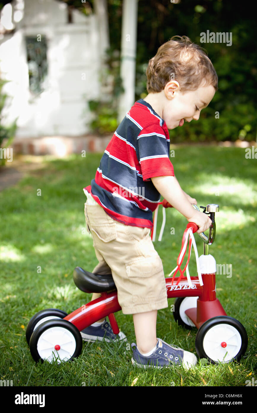 Young boy riding a tricycle Stock Photo Alamy
