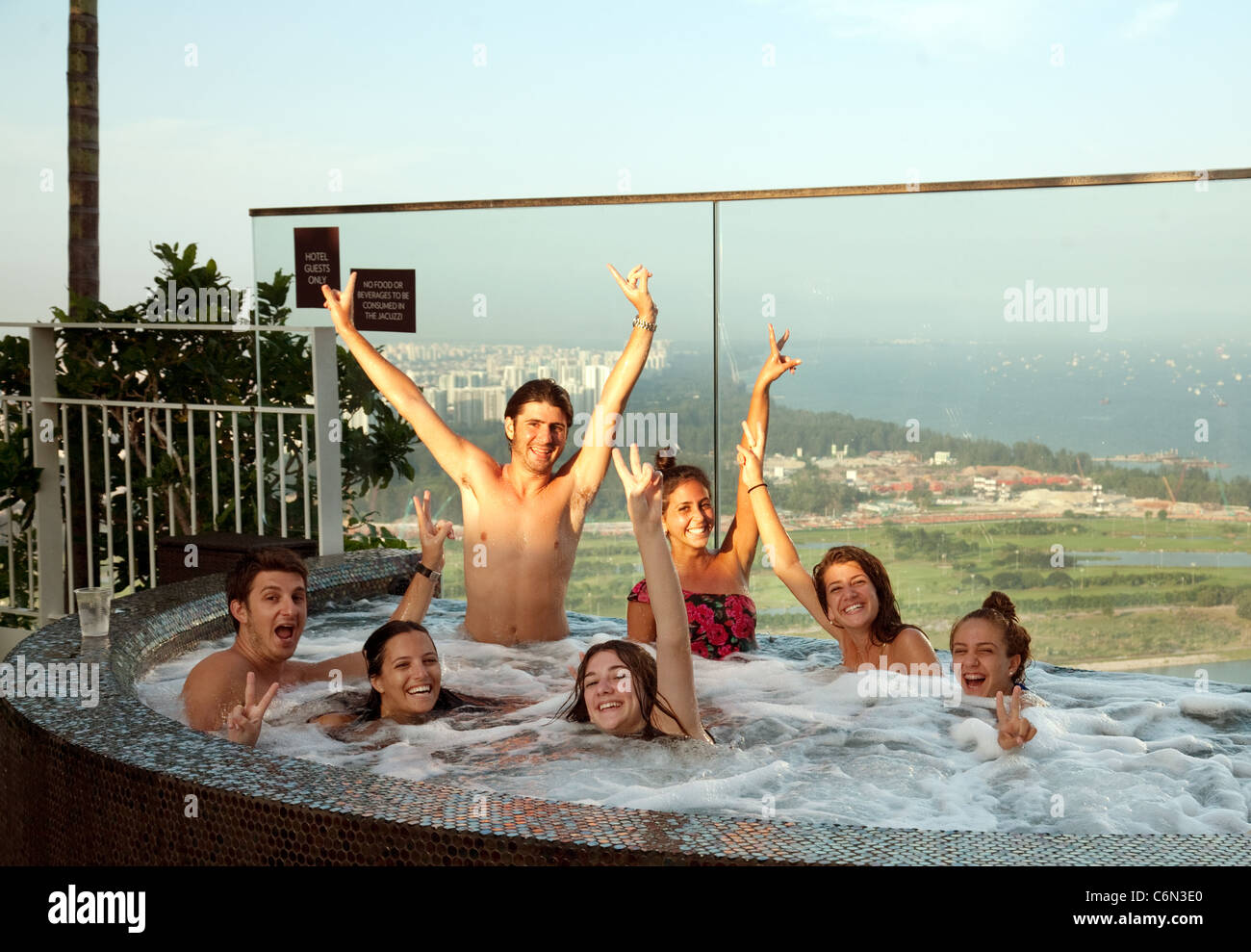 Young people enjoying a jacuzzi in the skypark at the top of the Marina Bay Sands hotel, Singapore Asia Stock Photo