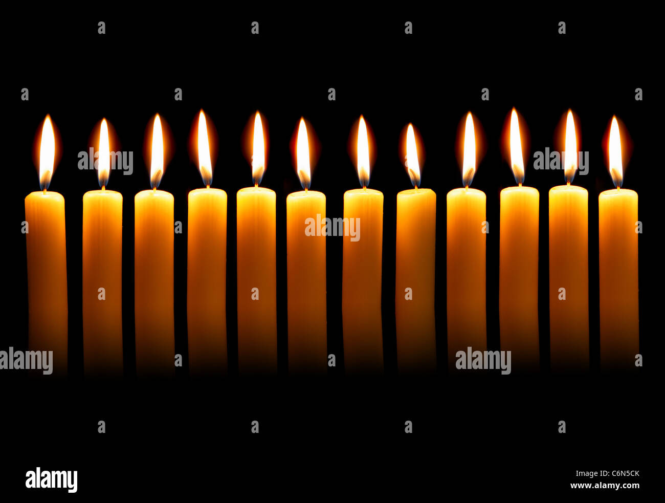 Twelve alight candles over the black background Stock Photo - Alamy
