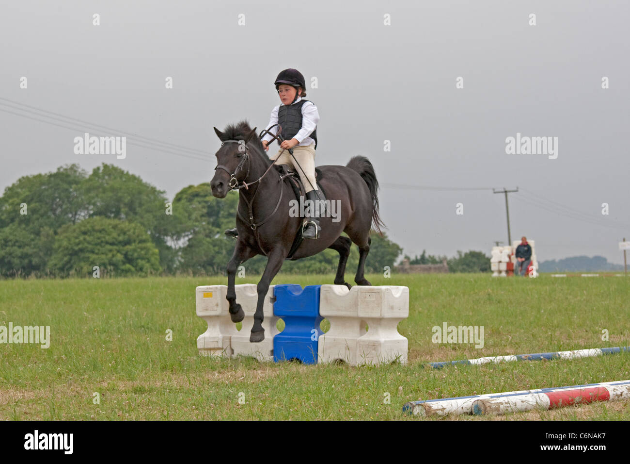 Young girl rider in mid air over jump North Cotswold Pony Club Camp 2011 Stock Photo