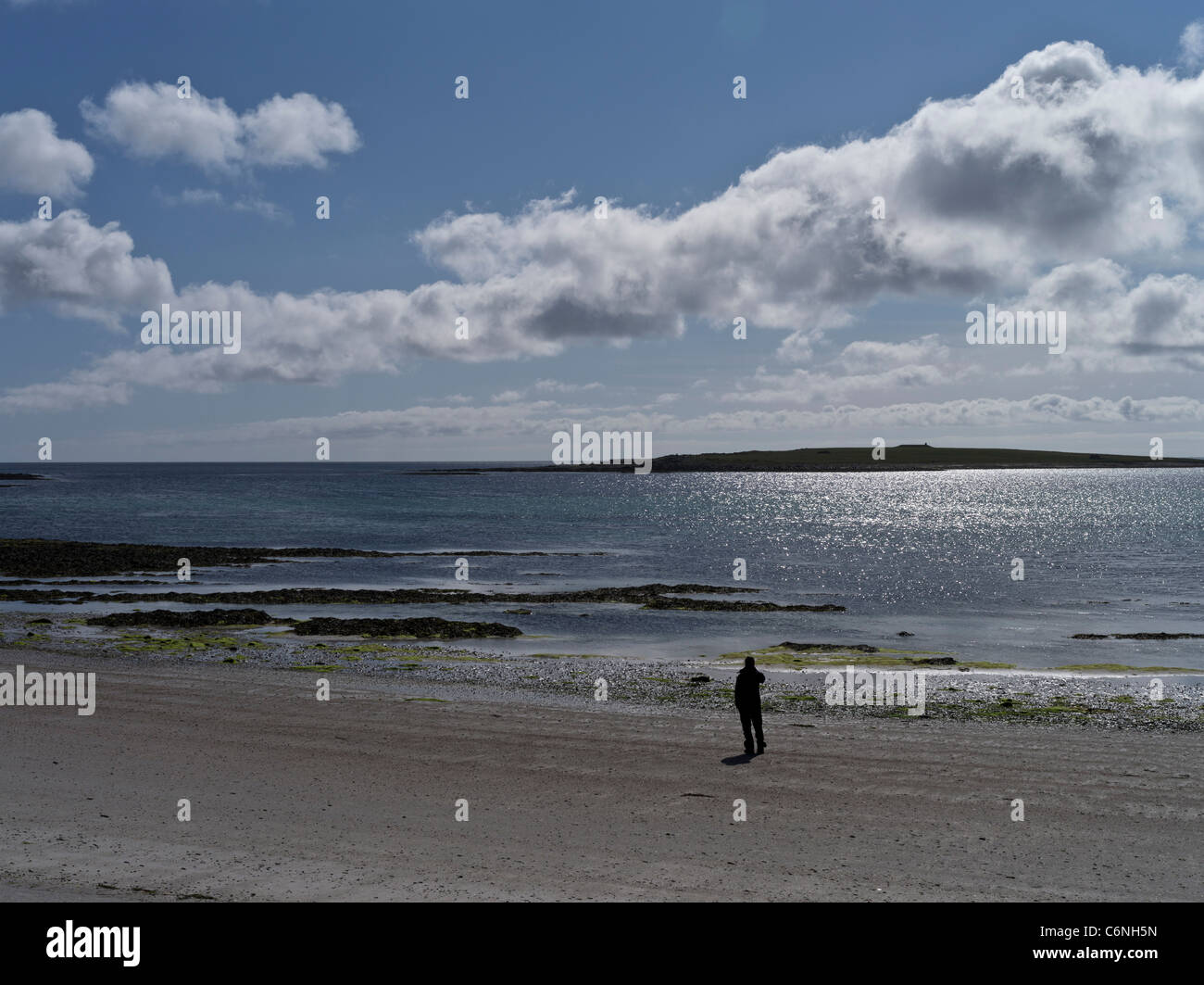 dh South Wick PAPA WESTRAY ORKNEY Scottish Tourist person on beach Holm of Papa island alone bench sea woman north islands remote uk Stock Photo