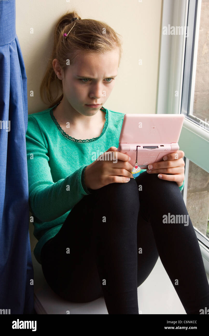 Eleven year old girl playing with a computer game Stock Photo Alamy