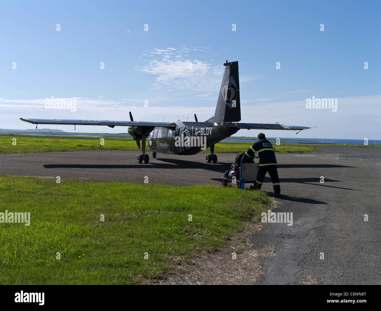 dh Loganair aircraft Scotland PAPA WESTRAY ORKNEY ISLES Baggage handler loading plane island small airplane islands airport luggage ground crew Stock Photo