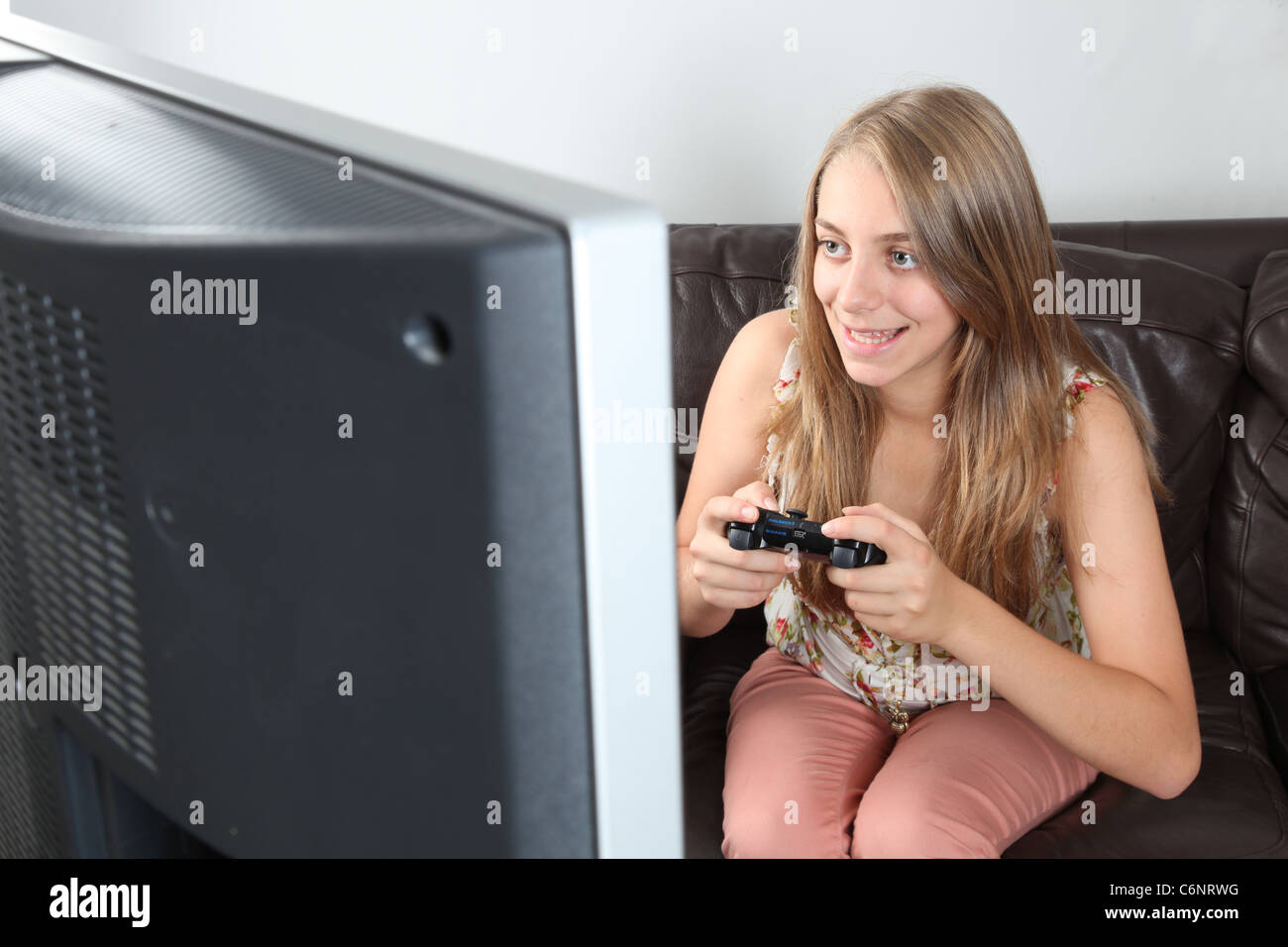 Teenage girl holding a controller smiling. Stock Photo