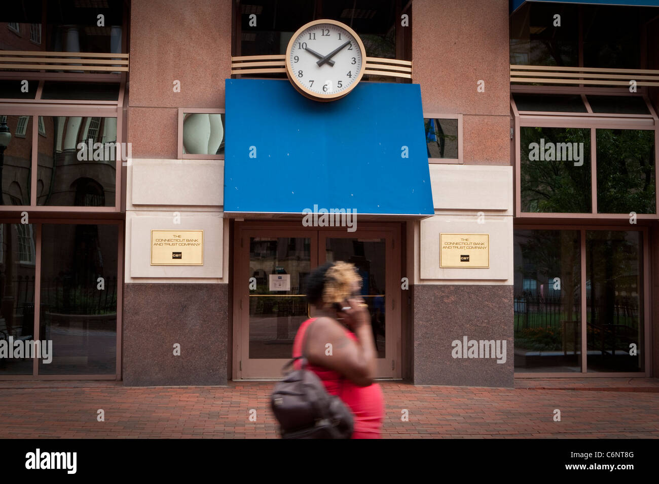 A woman walks by a Connecticut Bank and Trust Company branch in Hartford, Connecticut, Saturday August 6, 2011. Stock Photo