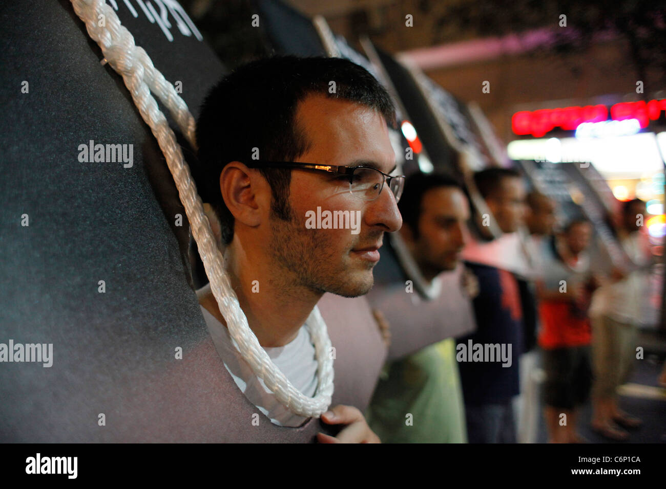 Demonstrators with rope noose around their neck part in a Social Justice protest in Tel Aviv Israel. The social justice protest also named the Tents protest were a series of demonstrations beginning in July 2011 in which more than half a million Israelis took to the streets opposing the continuing rise in the cost of living particularly housing. Stock Photo