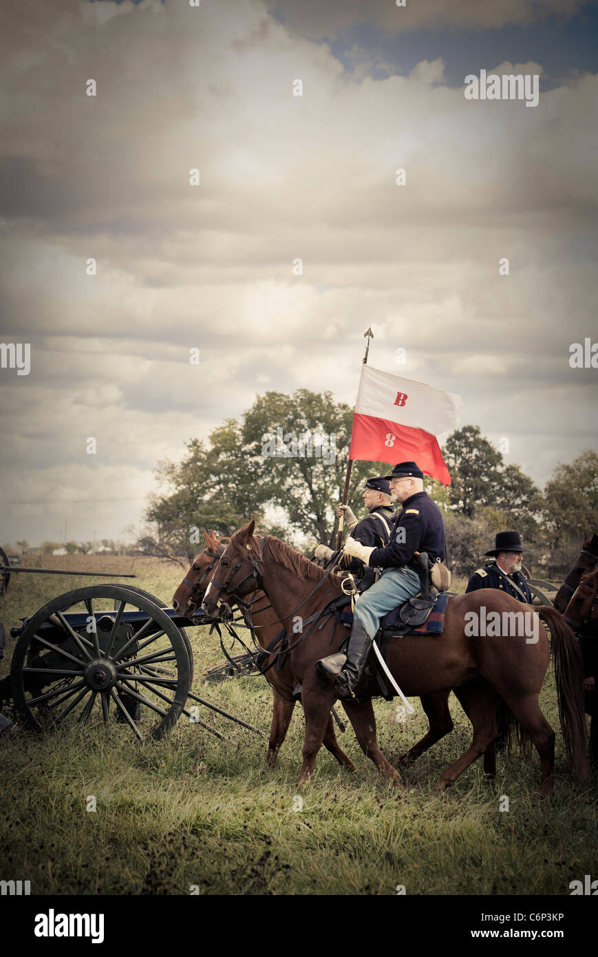 Civil war reenactors dressed as soldiers ride horses into battle Stock Photo