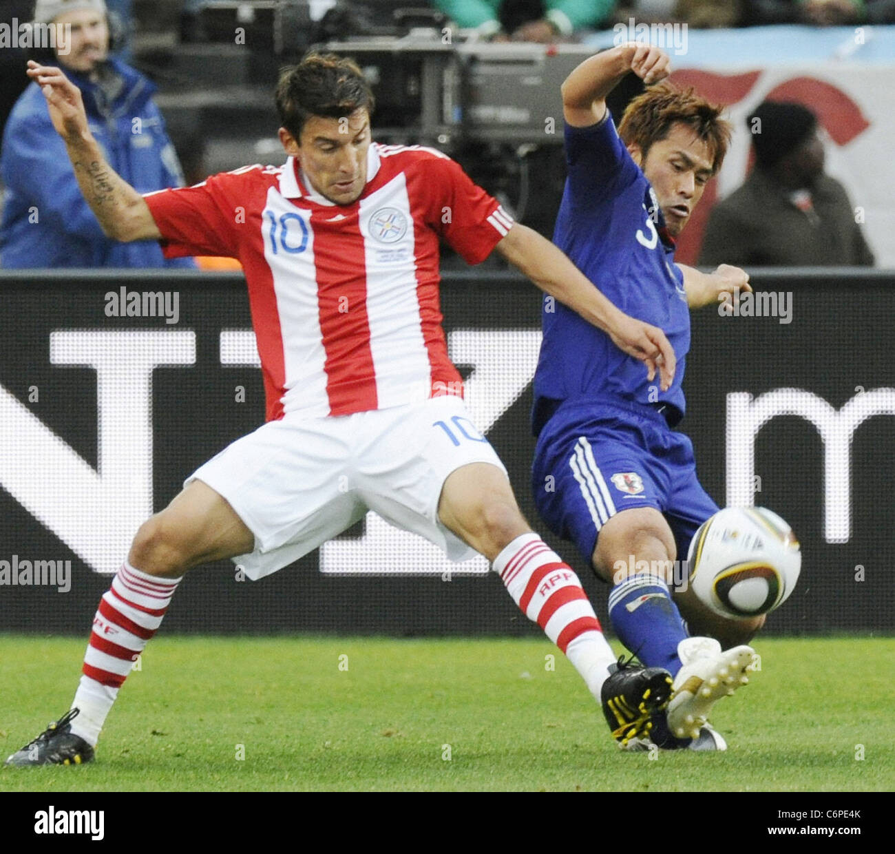 Japan defender Yuichi Komano (R) competes for the ball with Paraguay