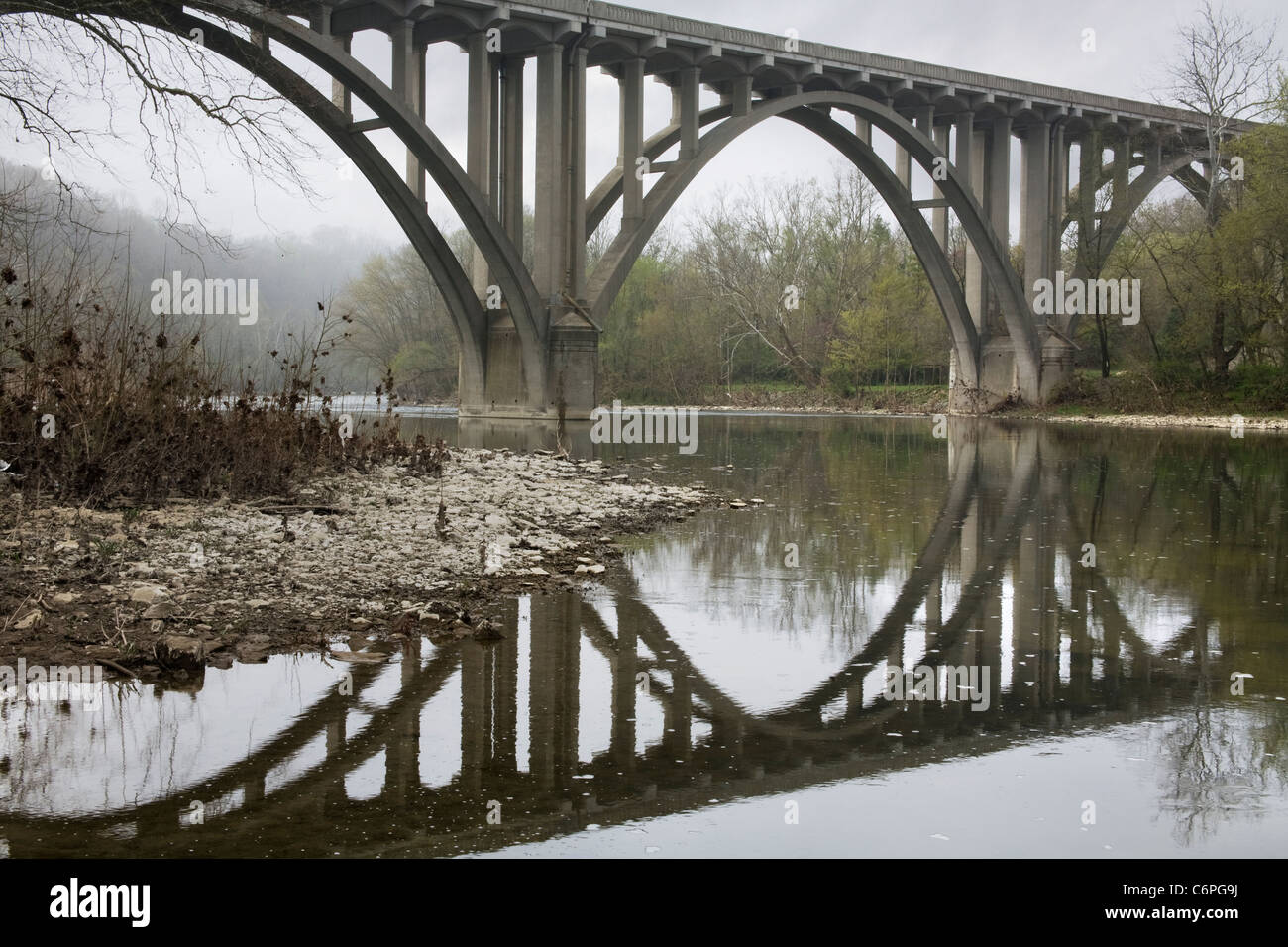The Mirror Like Reflection Of A Highway Bridge On A Misty Morning Over The Little Miami River, Southwestern Ohio, USA Stock Photo