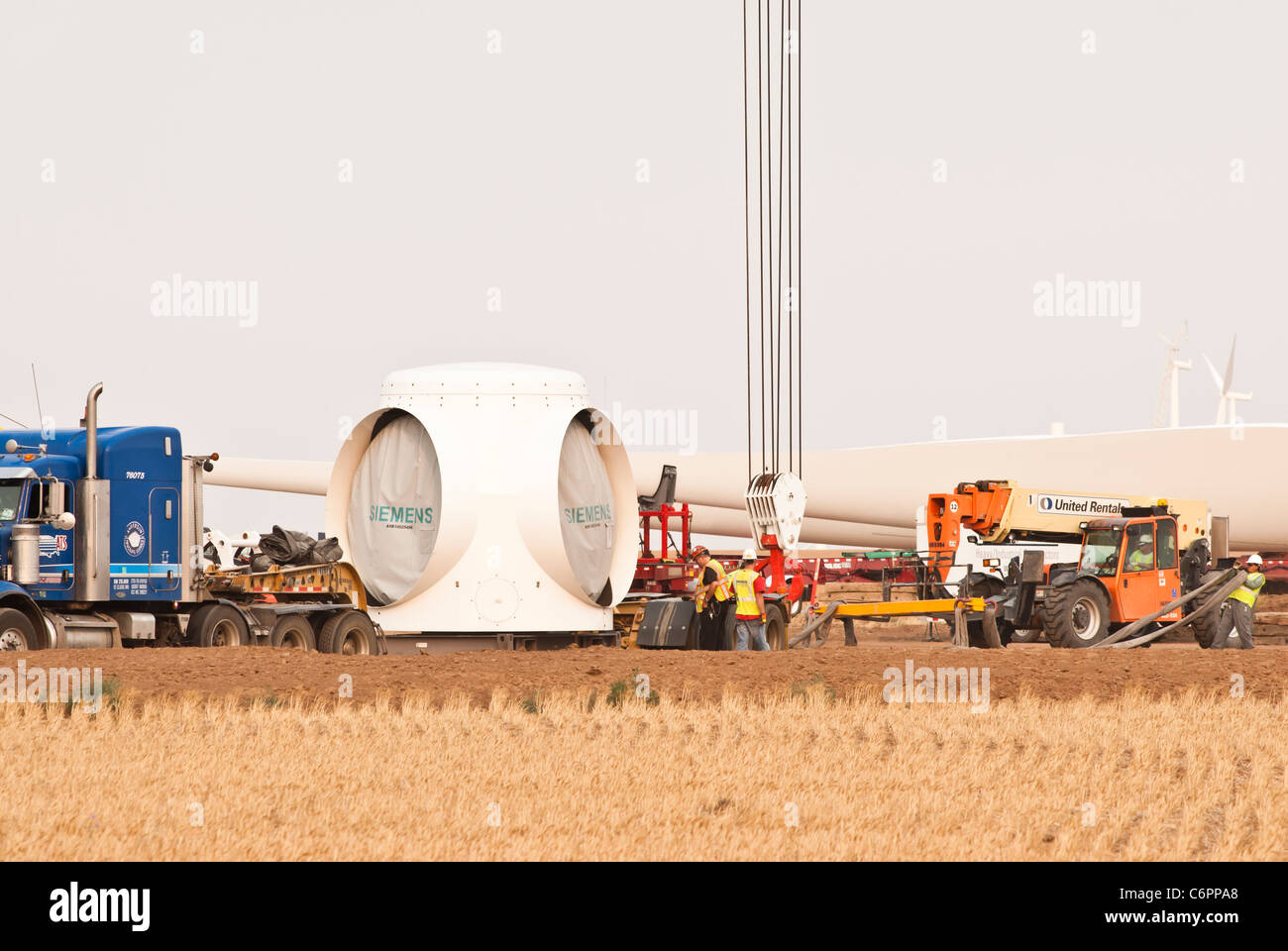Components for a horizontal-axis wind turbine are being assembled on a tower in a construction site near Amarillo, Texas. Stock Photo