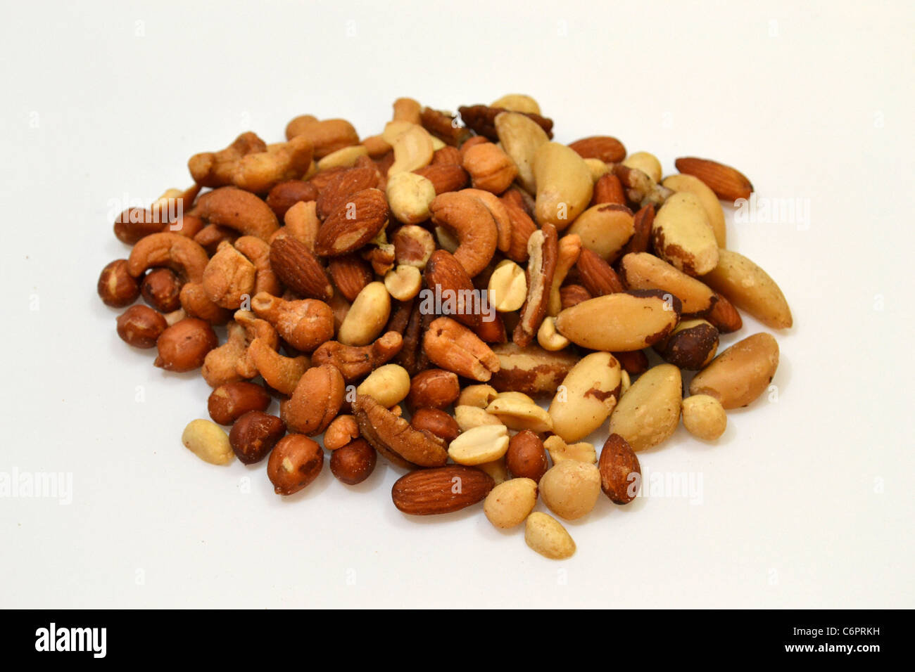 A pile of mixed nuts laying on a plain white background. Stock Photo