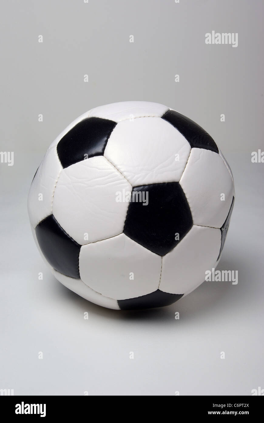A soccer ball sits on a plain white background. Stock Photo