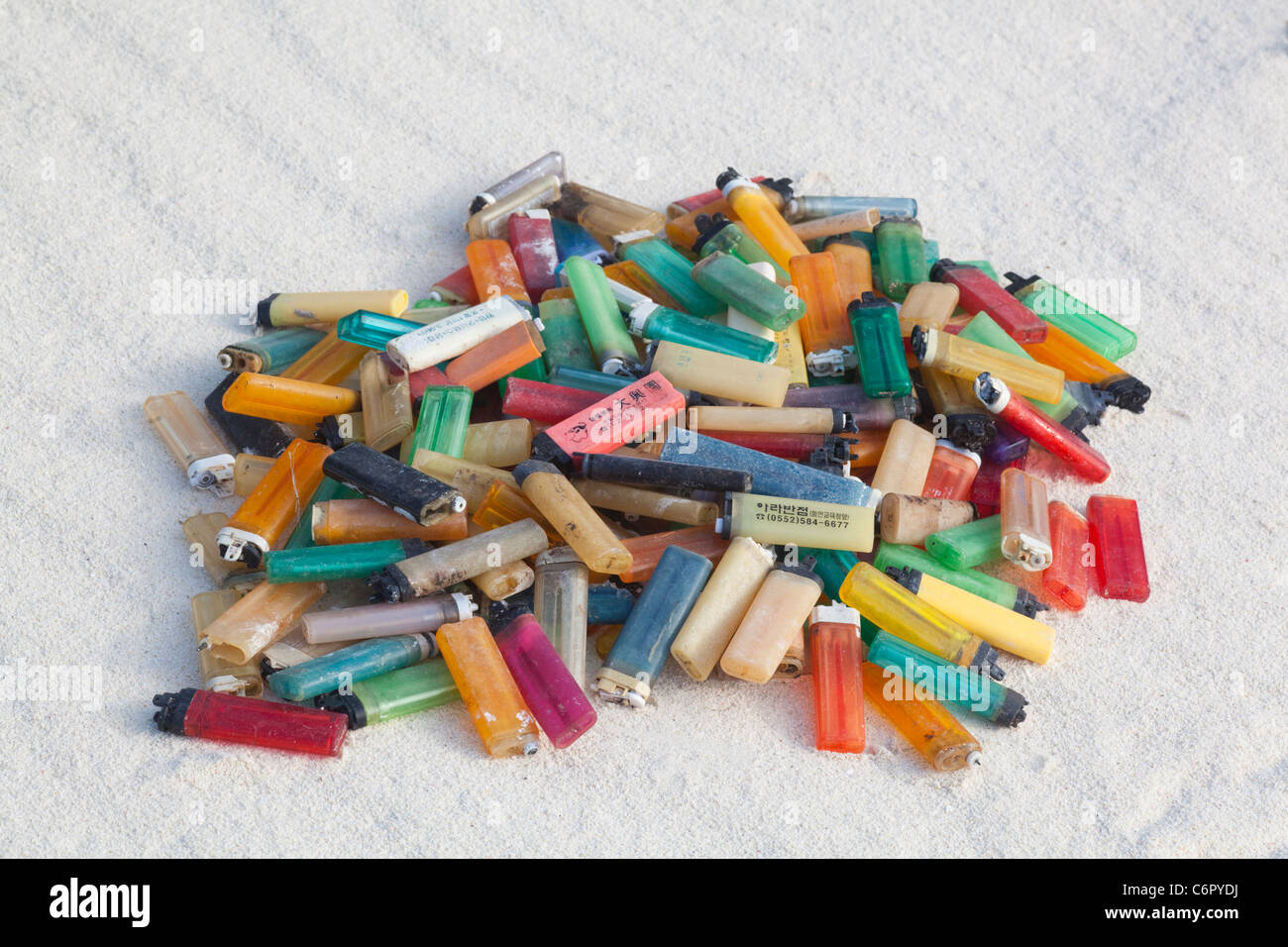 Cigarette lighters that washed ashore on a pacific island beach and were collected by tourists to prevent harm to seabirds and other wildlife Stock Photo