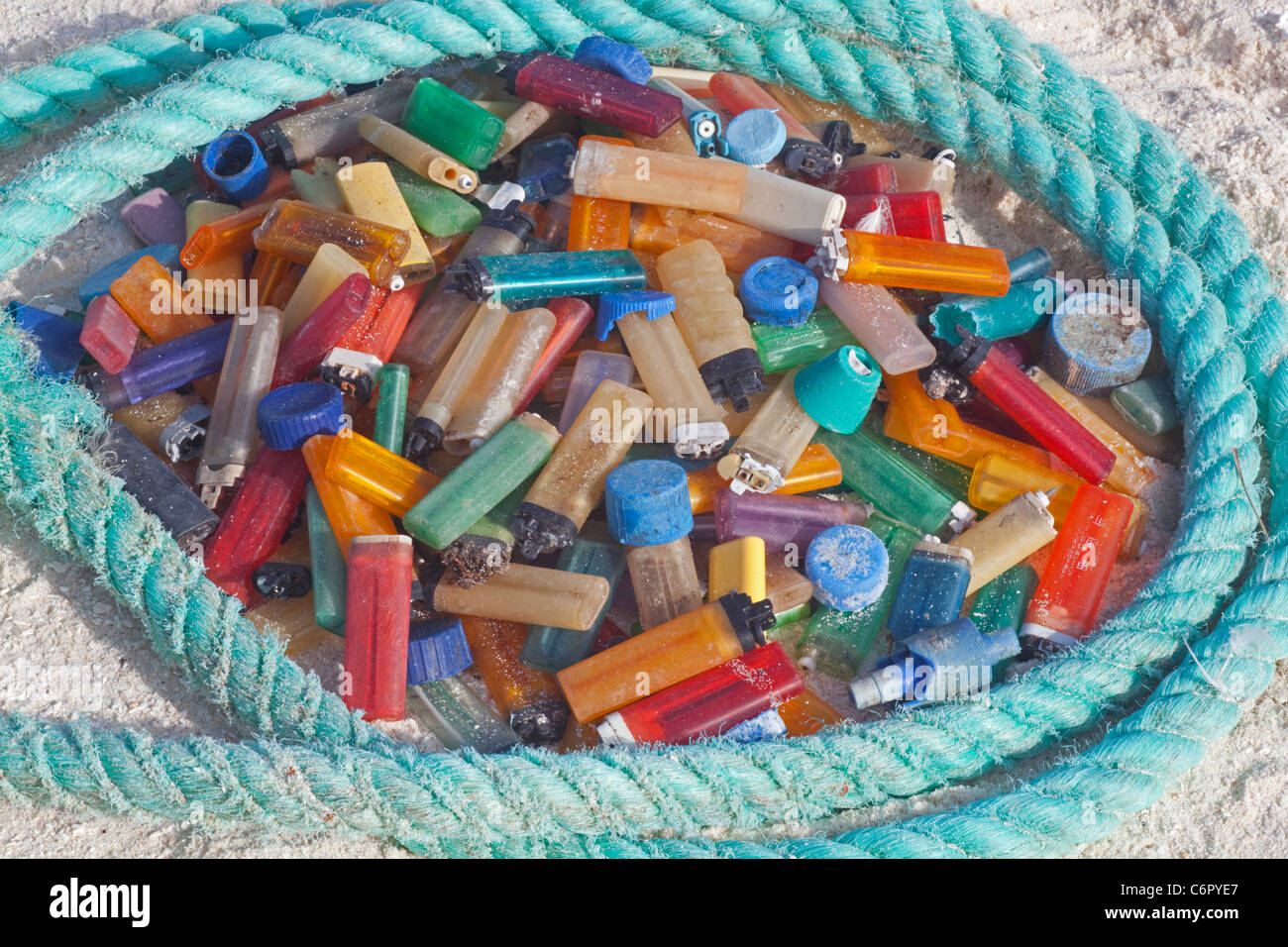 Cigarette lighters and rope, marine debris washed ashore on a pacific island then collected by tourists to prevent harm to seabirds or other wildlife Stock Photo