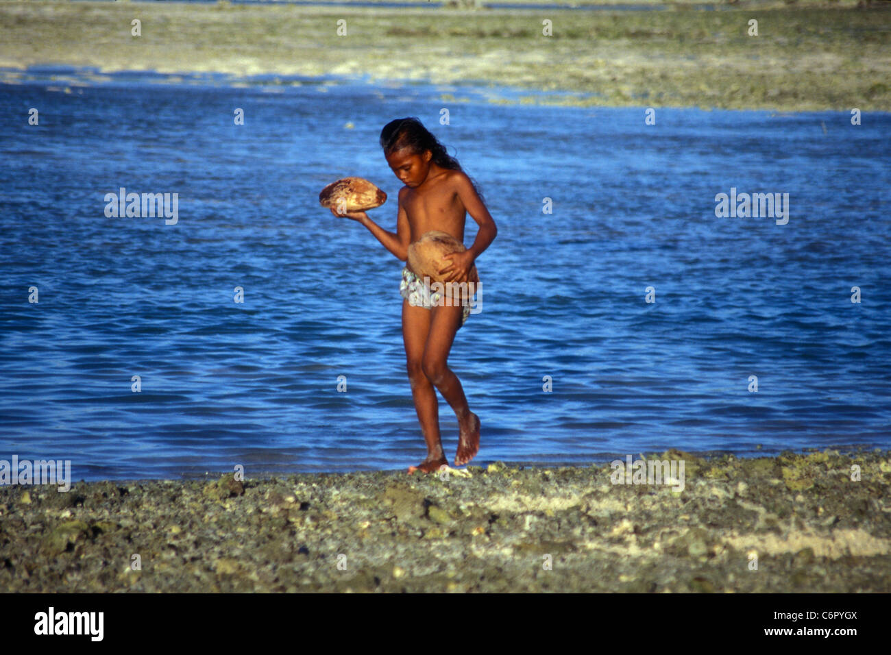 Girl beachcombing at low tide, Tarawa, Kiribati, Central Pacific Stock Photo