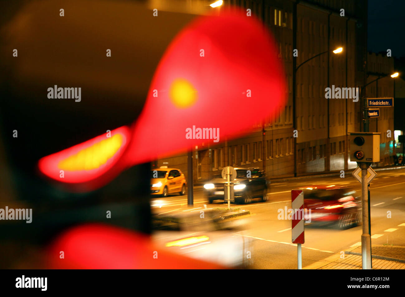Traffic camera, at a traffic light, inner city street crossing, controls cars driving over red light signal. Stock Photo