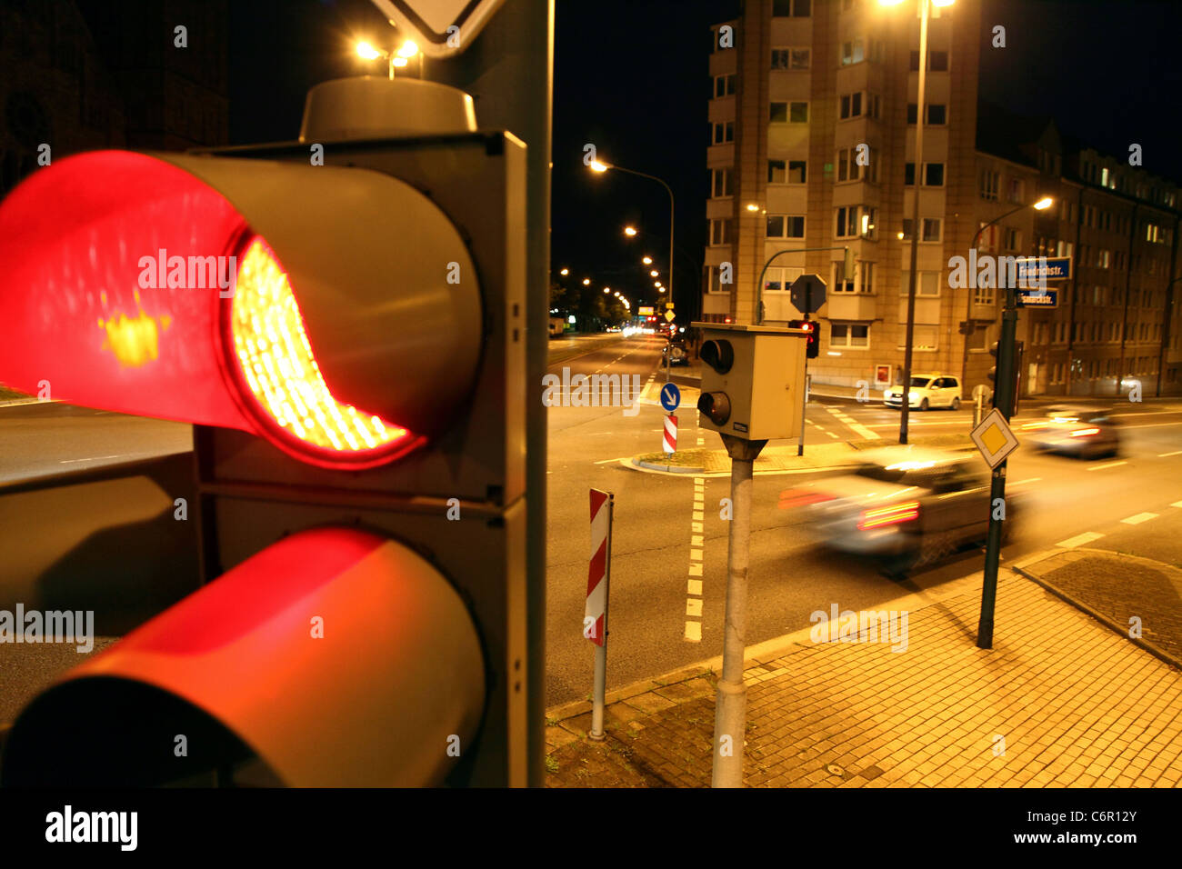 Traffic camera, at a traffic light, inner city street crossing, controls cars driving over red light signal. Stock Photo