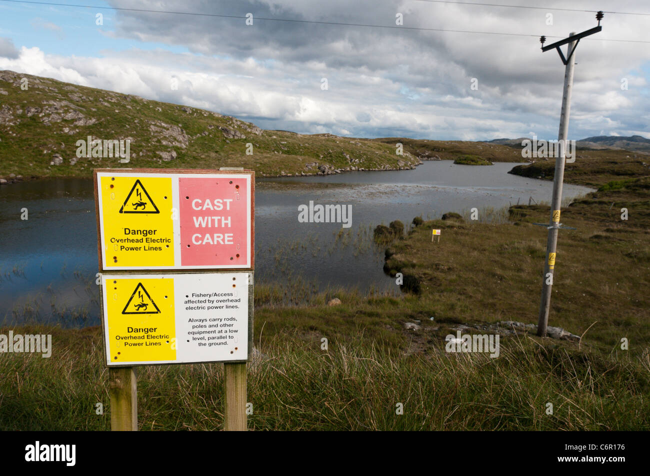 A Health and Safety sign warns of the dangers of fishing rods touching overhead power lines Stock Photo